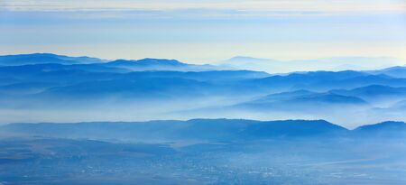 Landscape with morning fog in blue mountain valley. Low Tatra mountains in Slovakiaの写真素材