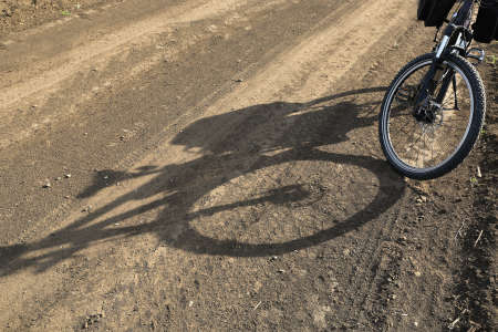 bike and shadow on dirt roadの写真素材