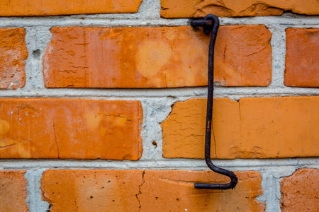 Old rusty hook and red brickwork wall backgroundの写真素材