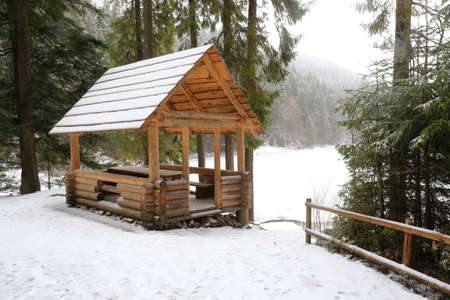 wooden gazebo in the winter forestの写真素材