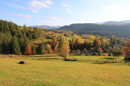 Majestic landscape with rural meadow in autumnal Carpathian mountains, Ukraineの写真素材