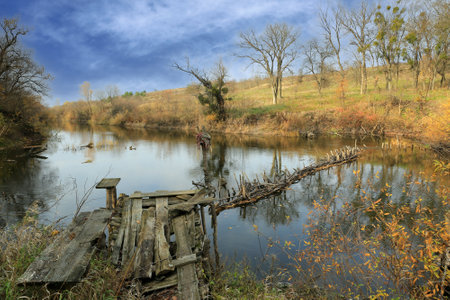 landscape with old fishing bridge on river in autumn timeの写真素材