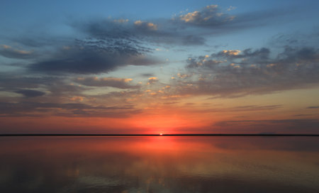 majestic sunset landscape over lake water surfaceの写真素材