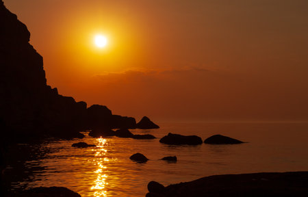 Sunset landscape over rocky sea shoreの写真素材