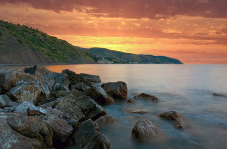 Nice Sunset landscape with stones on sea shoreの写真素材