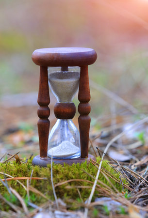 Abstract vintage hourglass on moss in parkの写真素材