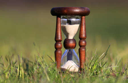 Abstract hourglass in green grass - soft photo