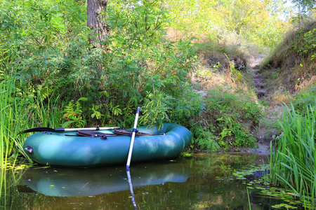 Inflatable boat for fishing with oars on the river bankの写真素材