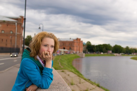 Beautiful thoughtful girl stands near the riverの写真素材