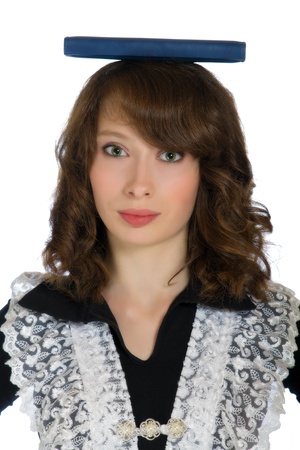 beautiful teen girl holding a book on his headの写真素材