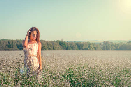 Portrait of a beautiful young woman among a field of flowersの写真素材