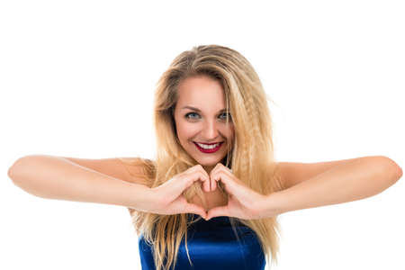 Portrait of a beautiful young happy woman on a white background. She does hands heartの写真素材
