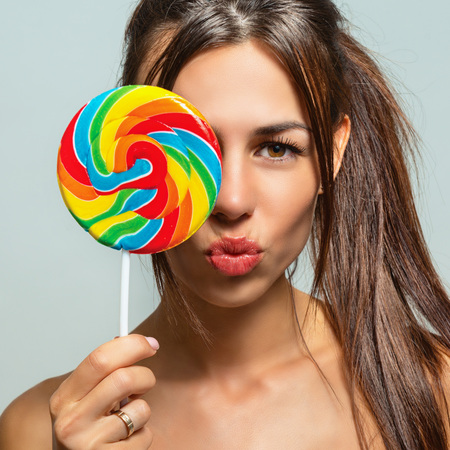 Portrait of a beautiful sexy woman with candyの写真素材