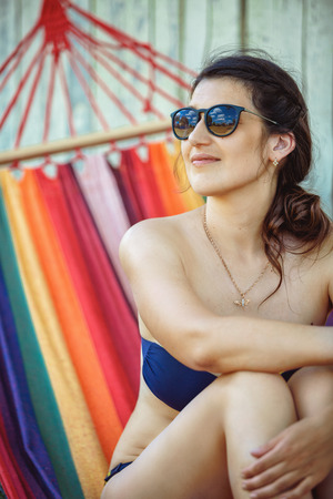 Portrait of a beautiful adult woman in a swimsuit and sunglassesの写真素材