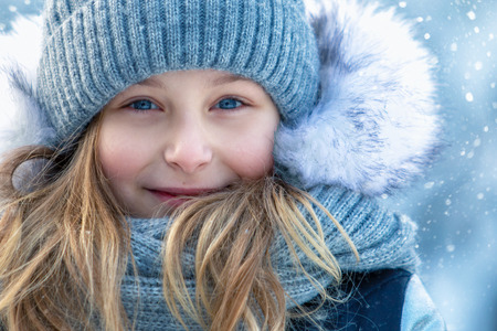 Portrait of a beautiful smiling girl in winter outdoors. Face close upの写真素材