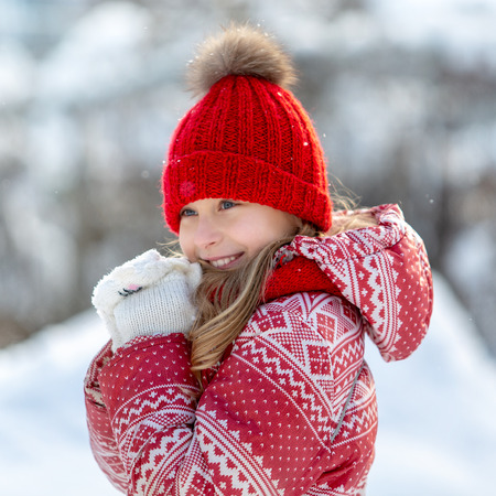 Portrait of a happy child in the winter. Cheerful girl outdoorsの写真素材