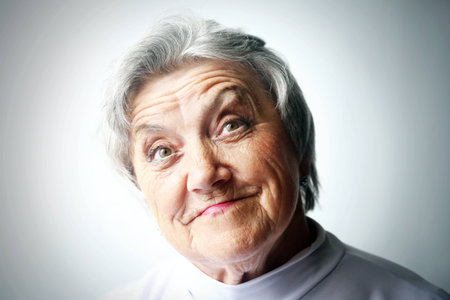 Looking old woman portrait on a grey backgroundの写真素材
