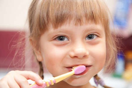 A young girl brushing her teeth in bathroom.の写真素材