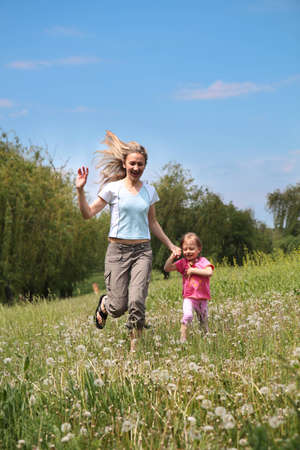  Mother and daughter walking on path holding handsの写真素材