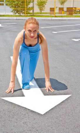 Athletic a woman in start position on trackの写真素材