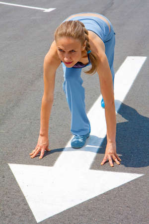 Athletic woman in start position on  track  の写真素材