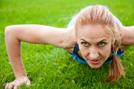 A caucasian female doing push ups in the parkの写真素材