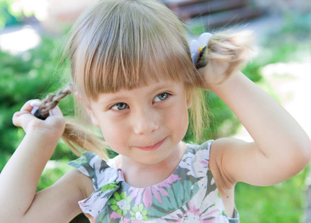 A Beautiful little smilegirl with pigtails outdoor.の写真素材