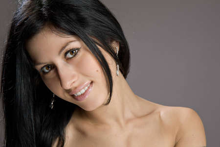 Portrait of beautiful sexy brunette on a gray backgroundの写真素材