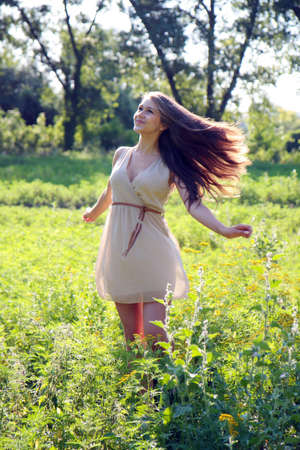 Beautiful young girl in a meadow.の写真素材