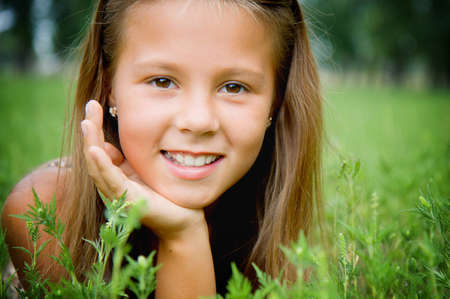 Portrait of a smiling girl on the grass の写真素材