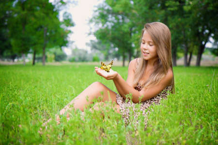 Little girl with a butterfly in his hands の写真素材