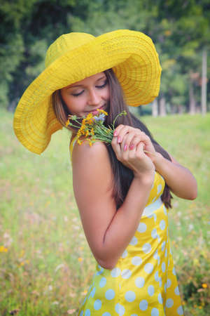 Beautiful girl with flowers in the meadowの写真素材