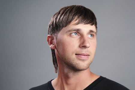 Portrait of a young man on a gray background.