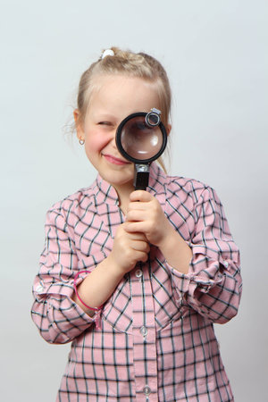 Funny girl explores with a magnifying glass の写真素材