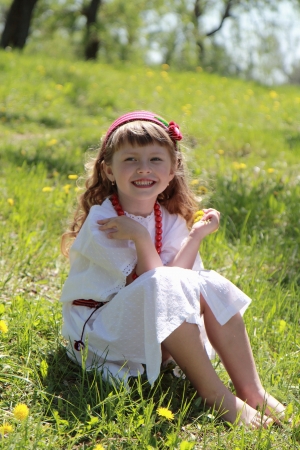Little girl in the Ukrainian national costume on grass.の写真素材