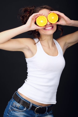 Cheerful young woman with citrus.の写真素材