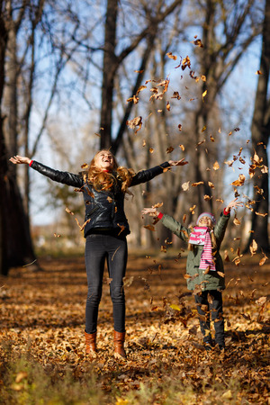 Young mother and her toddler girl in autumn parkの写真素材