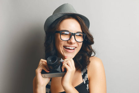 Beautiful attractive girl in a hat with camera.の写真素材