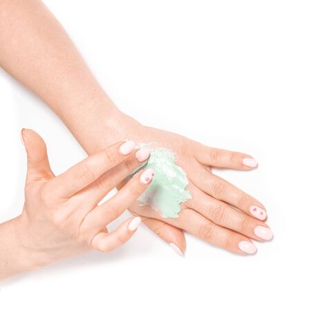 View from above woman's hands apply homemade skin care mask. Woman smearing mud maskの写真素材