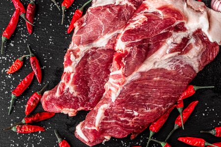 two pieces of fresh marbled beef on a dark background, with spices for cooking steak, horizontalの写真素材