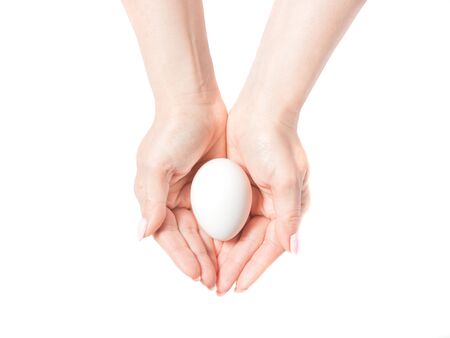 Woman hands with white egg isolated on white background, conceptの写真素材