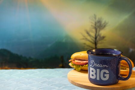 Morning cup of coffee and sandwich with mountain background at sunrise,の写真素材