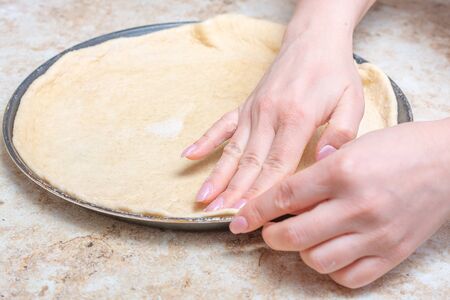 Making a pizza at home with tomato and cheese. Cook at home conceptの写真素材