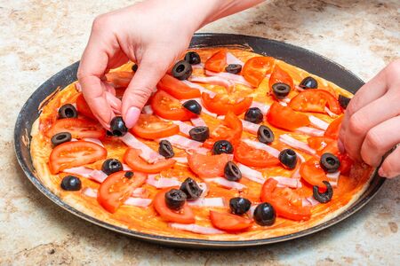 Making a pizza at home with tomato and cheeseの写真素材