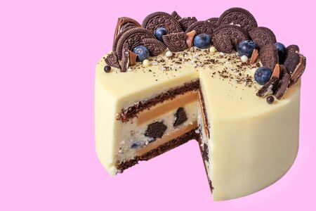 beautiful cake on a purple, decorated with blueberries and cookies, triangular section shown isolated on purple background, close-upの写真素材