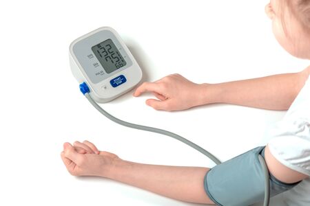 child girl measures her blood pressure herself, pediatric cardiology concept, isolated white backgroundの写真素材