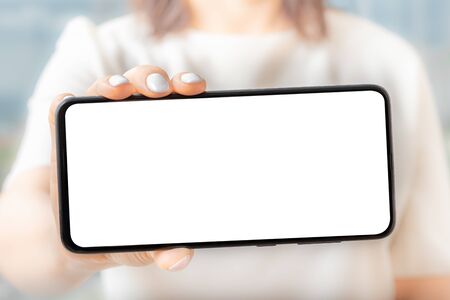 Women hold and show smartphones front view, Women hand show the mobile phone at the white screen, mockupの写真素材
