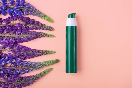Wild flowers violet lupin on a pink background. Top view, flat lay. mockup natural cosmeticsの写真素材
