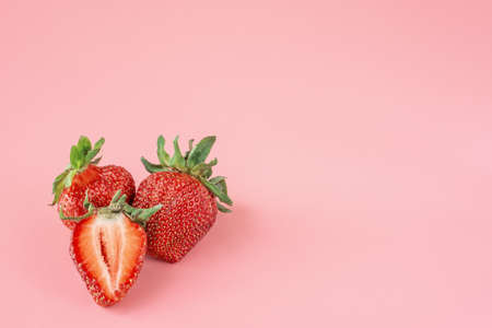 Few strawberries on a pink background. Fresh red organic strawberries. Fresh strawberry smoothie, summer healthy antioxidant. copyspace.の写真素材