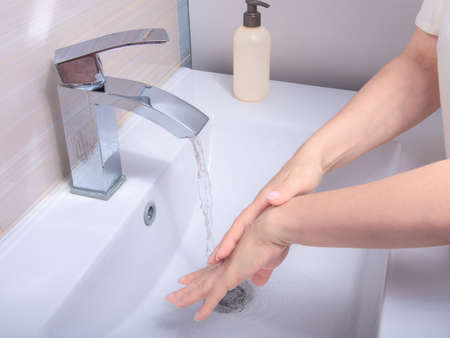 Coronavirus pandemic prevention wash hands with soap warm water, rubbing nails and fingers washing...